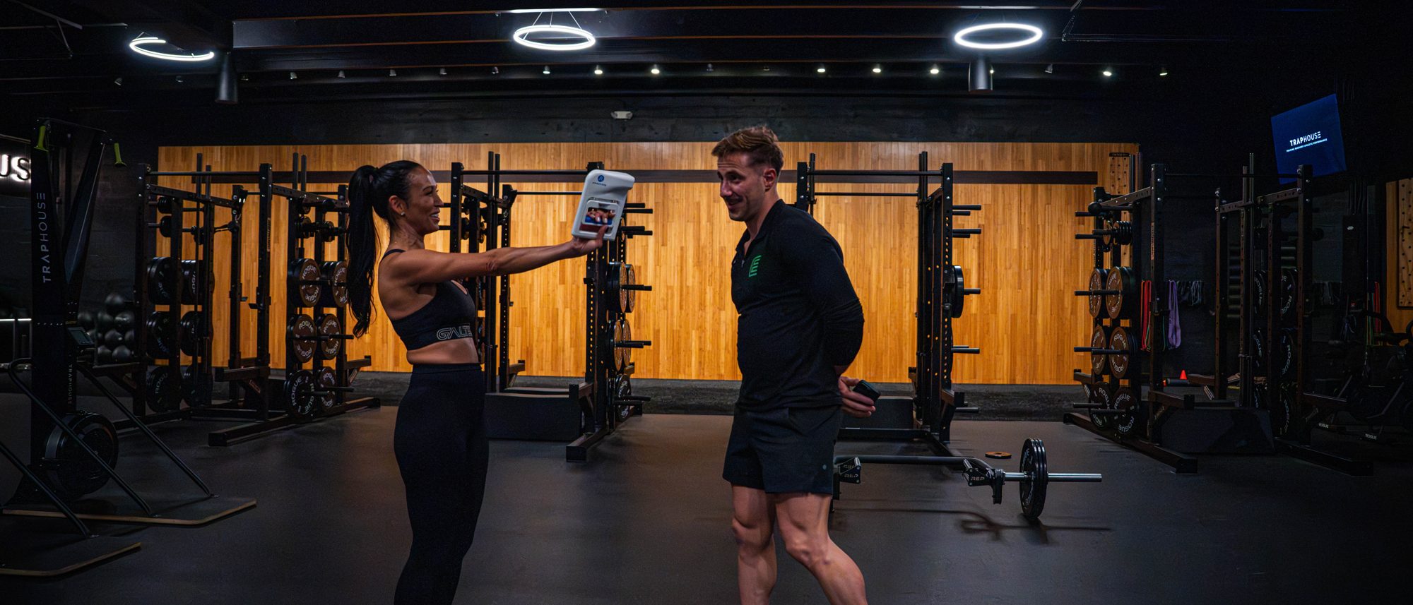 The training floor: racks, a wood wall, Damjan and a client at the far end